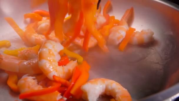 Креветки и паприка падают в сковороду с маслом — стоковое видео