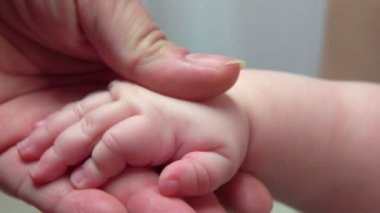 Bir yetişkin el parmakları ile tutarak bebek