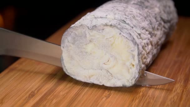 Keçi peyniri gri küf ile ahşap bir gemide bir bıçak ile kesmek — Stok video