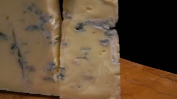 Slow-motion of blue cheese falling on the wooden board — Stock Video