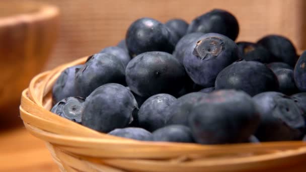 Hand puts a juicy blueberry in a wicker basket — Stock Video