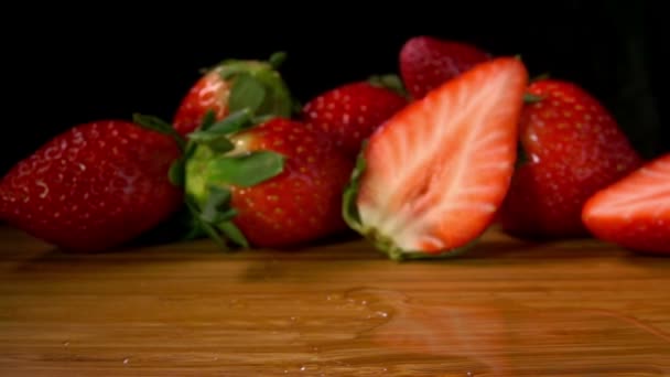 Zralé jahody na mokré dřevěné desce — Stock video