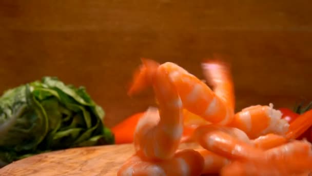 Juicy shrimp falling on a wooden board — Stock Video
