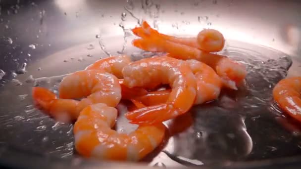 Очищенные креветки кладут на сковородку с водой — стоковое видео