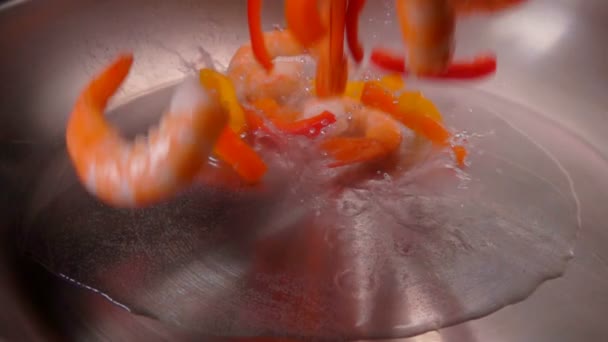 Gepelde garnalen vallen in een koekepan met olie — Stockvideo