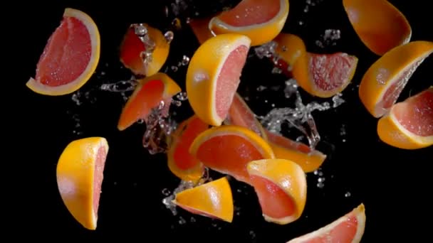 Rodajas de pomelo con agua vuelan a la cámara — Vídeo de stock