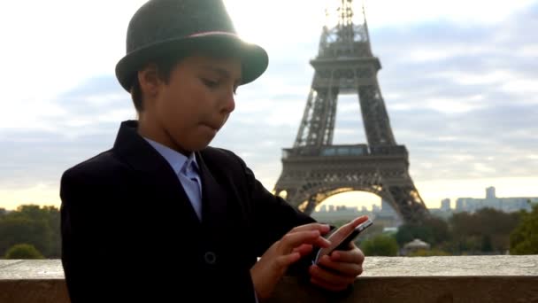 Niño en el sombrero escribe mensajes en el teléfono inteligente — Vídeo de stock
