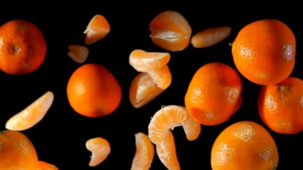 Ломтики и целые мандарины летят к камере — стоковое видео
