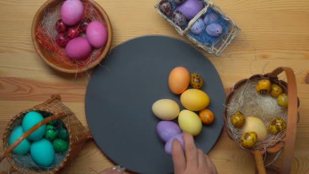 Womans hand takes colored easter eggs from different baskets — Stock Video