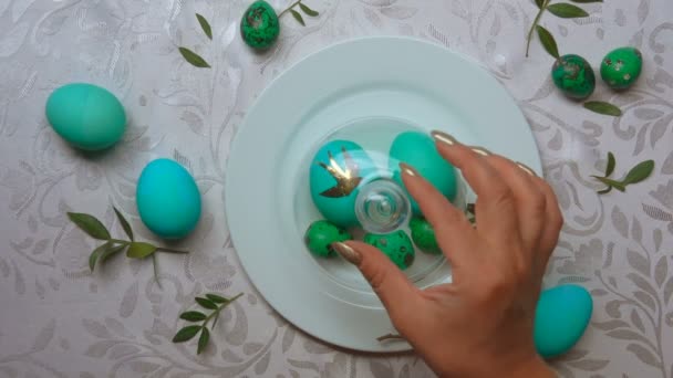 Main enlève un dôme de verre d'une assiette avec des œufs de Pâques verts — Video