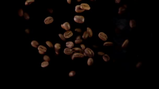 Los granos de café fritos vuelan a la cámara — Vídeo de stock