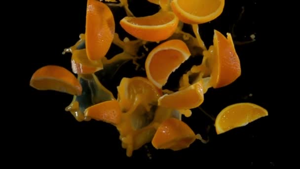 Orangenscheiben mit Saft fliegen in die Kamera — Stockvideo