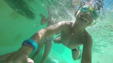 Gülümseyen ve su altında yüzmek çocuk