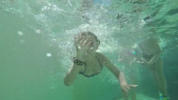 Dívka a chlapec plavání pod vodou — Stock video