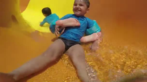 Lustige Kinderrolle mit gelben Wasserrutschen — Stockvideo