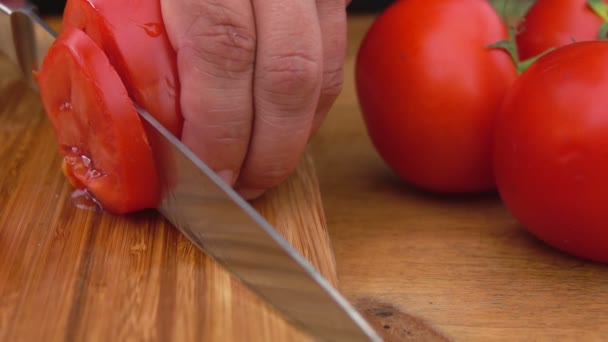 Cortar tomates con cuchillo en el tablero — Vídeo de stock