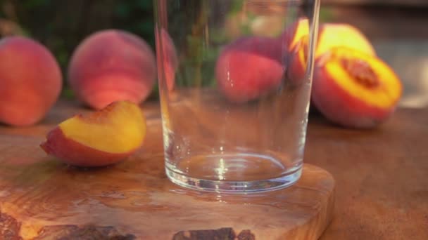 Sok brzoskwiniowy wlewa się do szklanki. — Wideo stockowe