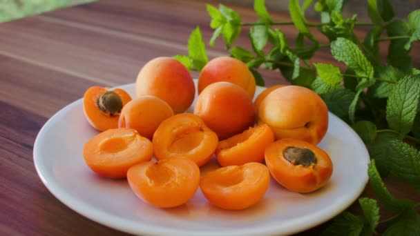 Ripe tasty apricot on a white plate — Stock Video