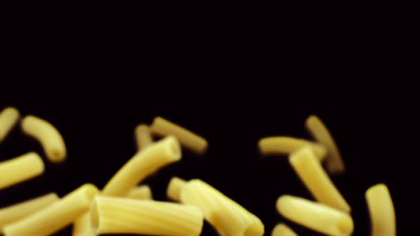 Pasta Penne vliegen in de lucht op zwarte achtergrond — Stockvideo