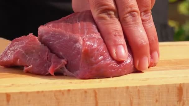 Fechar-se de uma mão que corta partes de carne fresca — Vídeo de Stock