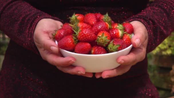 Handen stel voor een kom van aardbeien — Stockvideo