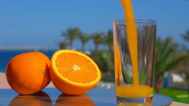 Gegoten in een glas sinaasappelsap — Stockvideo