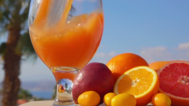Close-up suco de frutas múltiplas derramado em um copo de vinho — Vídeo de Stock