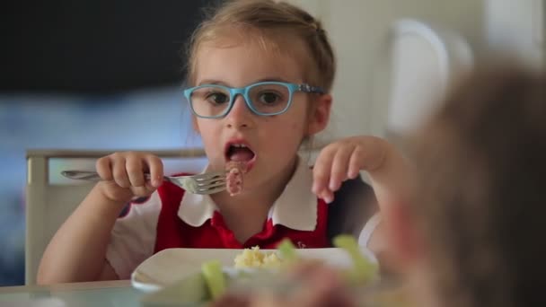 Menina está comendo para o almoço salsicha grelhada com purê de batatas — Vídeo de Stock