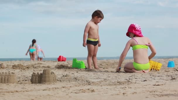 Küçük kız sahilde kumdan kaleler inşa ediyor — Stok video