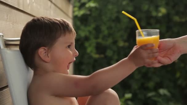 Pojke drink apelsin juice — Stockvideo