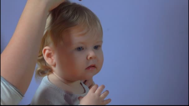 Mutter macht Pferdeschwanz aus Haaren ihrer kleinen Tochter — Stockvideo