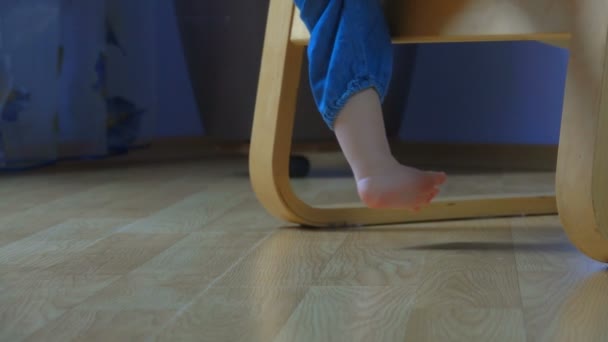 Blote voeten is kid naar beneden uit een fauteuil en onzeker lopen — Stockvideo