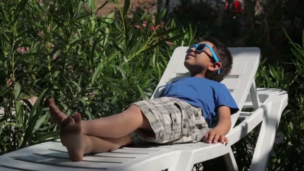 Niño en la playa con gafas de sol — Vídeo de stock