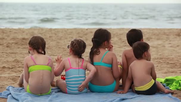 Les enfants mangent des sandwichs sur la plage — Video