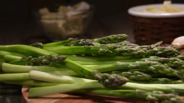Geschilde stengels van groene asperges vallen op tafel — Stockvideo