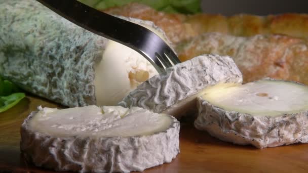 Vidlička si vezme plátek sýra Sainte maure se slámou — Stock video