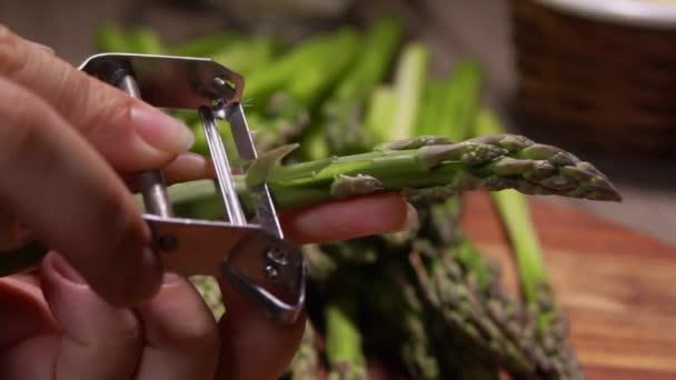 Manos pelan tallos de espárragos verdes con cuchillo — Vídeos de Stock