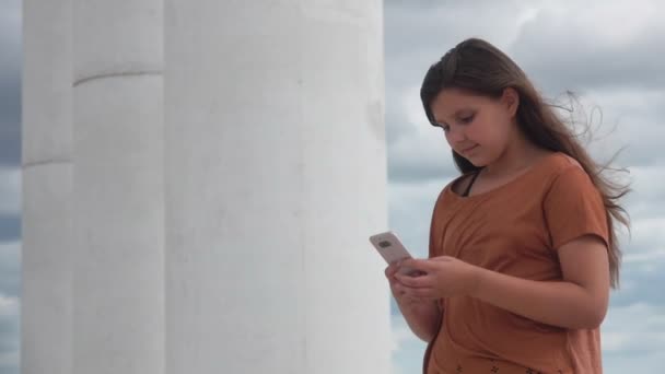 Beautiful girl in a brown t-shirt makes selfie — Stock Video