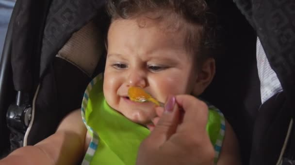 Krullend hongerig baby eet puree groenten — Stockvideo