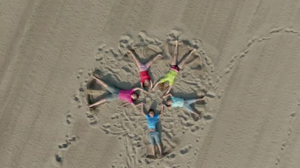 Kinderen trekken met hun voeten op het zand — Stockvideo