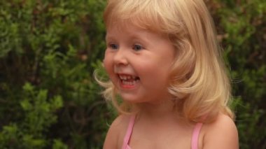 Sarışın kız şaşkınlık içinde gülümsüyor.