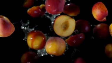 Şeftali yarımları su damlalarında uçar.