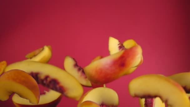 Peach slices bounce on a red background — Stock Video