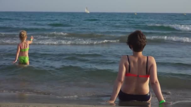 Mamma con una figlia tra le onde del mare surf — Video Stock