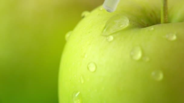 Une goutte d'eau coule dans une grande pomme verte juteuse — Video