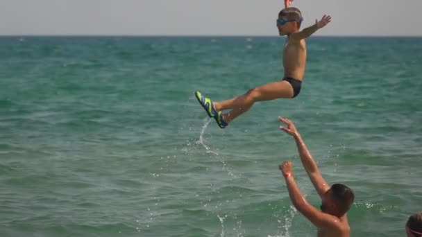 Rapaz feliz mergulha no mar com a ajuda do pai — Vídeo de Stock
