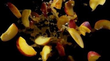 Şeftali dilimleri meyve suyu damlalarında uçar.