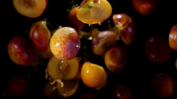 Helften perzik vliegen in spatten water — Stockvideo