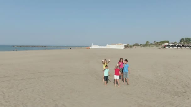Letecký záběr dětí mávajících rukama na pláži — Stock video