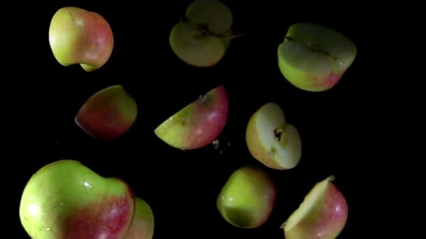 Helften appels vliegen omhoog op zwarte achtergrond — Stockvideo